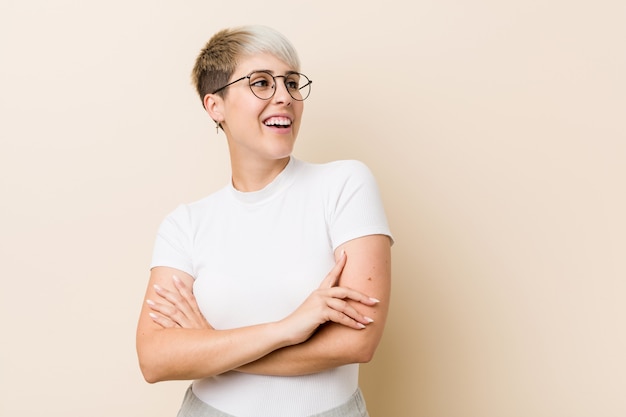 Young authentic natural woman wearing a white shirt smiling confident with crossed arms.