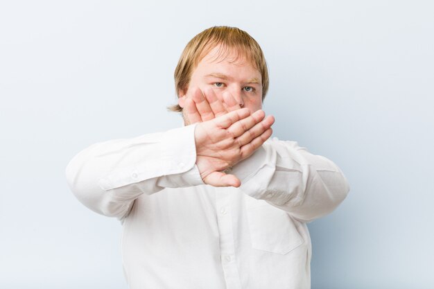 Young authentic redhead fat man doing a denial gesture