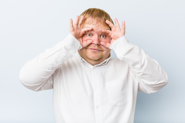 Young authentic redhead fat man showing okay sign over eyes