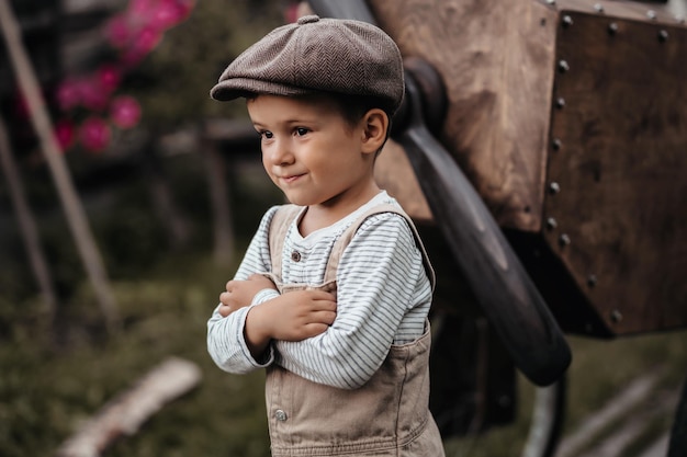 A young aviator boy near the propeller of a homemade airplane in a natural landscape Closeup Gives the picture an authentic mood Vintage