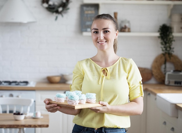 Young baker woman holding pastries Happy smiling and cheerful