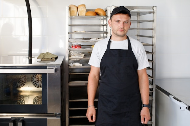 Young baker worker in a bakery in uniform