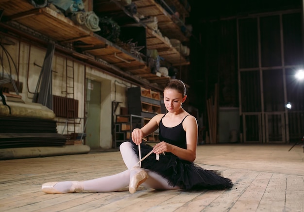 Young ballerina in black dress trains behind the scenes.