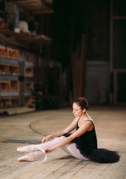 Young ballerina in black dress trains behind the scenes.