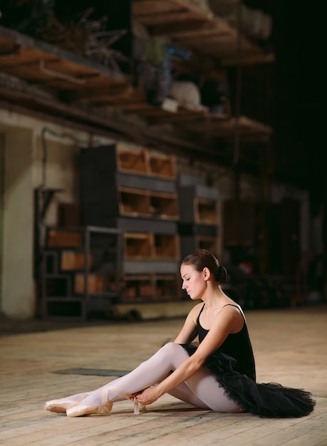 Young ballerina in black dress trains behind the scenes.