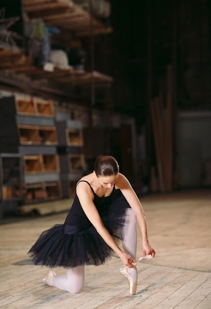 Young ballerina in black dress trains behind the scenes.