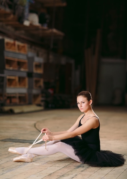 Young ballerina in black dress trains behind the scenes.