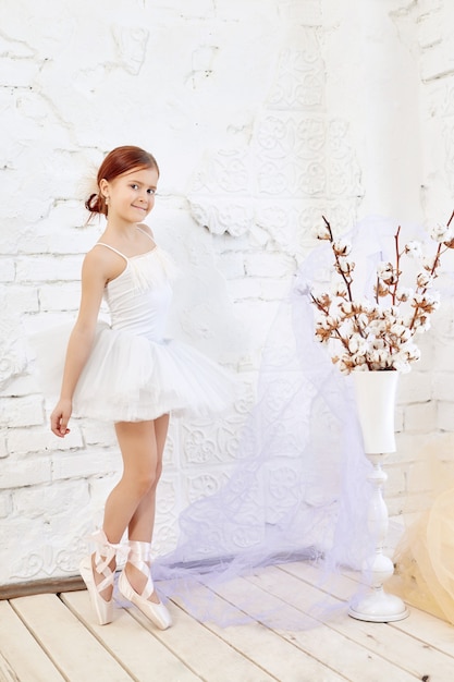 Young ballerina girl is preparing for a ballet 