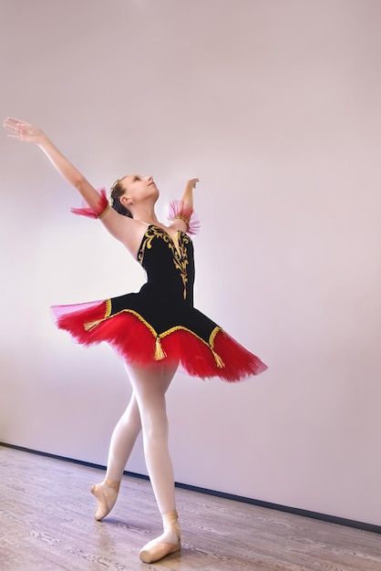 A young ballerina stands gracefully in pointe shoes on her toes in the studioBallet student practicing classical dance in studio before performance