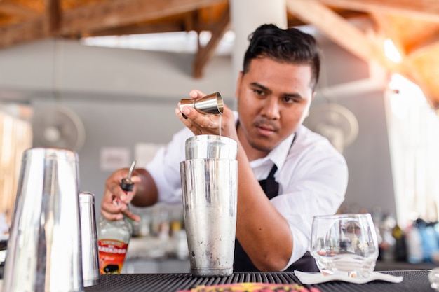 Young bartender pouring cocktail in a bar, Phuket, Thailand