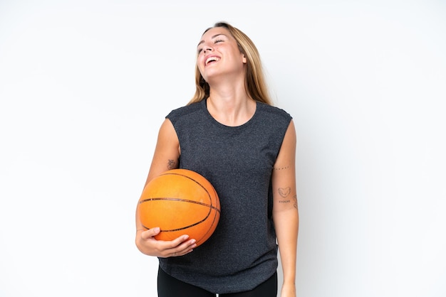 Young basketball caucasian player woman isolated on white background laughing