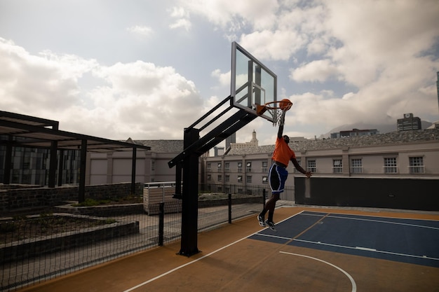 Young basketball player playing basketball in basketball court