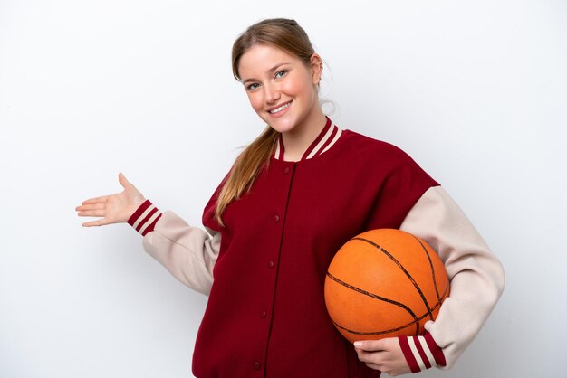 Young basketball player woman isolated on white background extending hands to the side for inviting to come