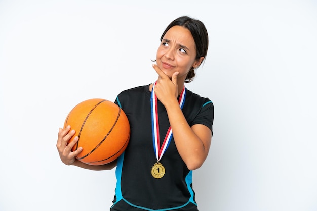 Young basketball player woman isolated on white background having doubts