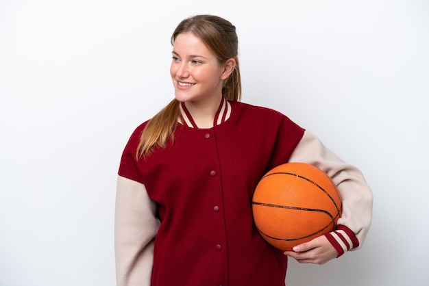 Young basketball player woman isolated on white background looking to the side and smiling