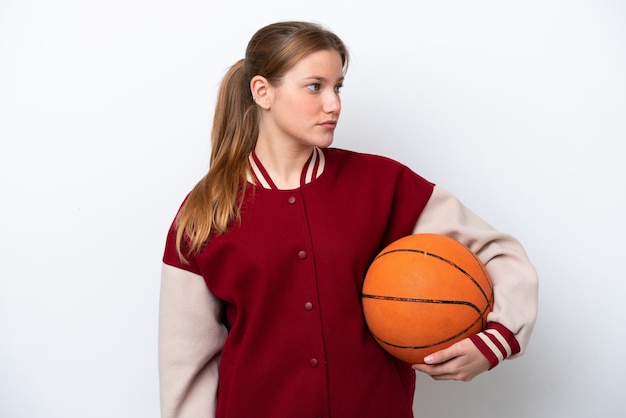 Young basketball player woman isolated on white background looking to the side