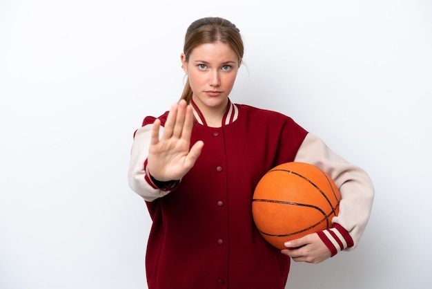 Young basketball player woman isolated on white background making stop gesture