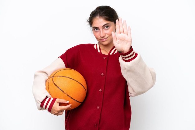 Young basketball player woman isolated on white background making stop gesture