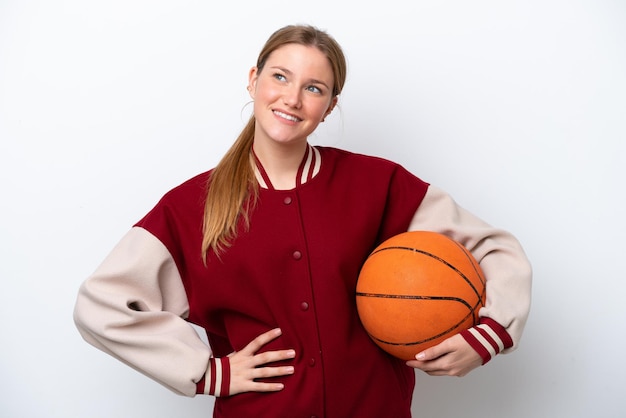 Young basketball player woman isolated on white background posing with arms at hip and smiling