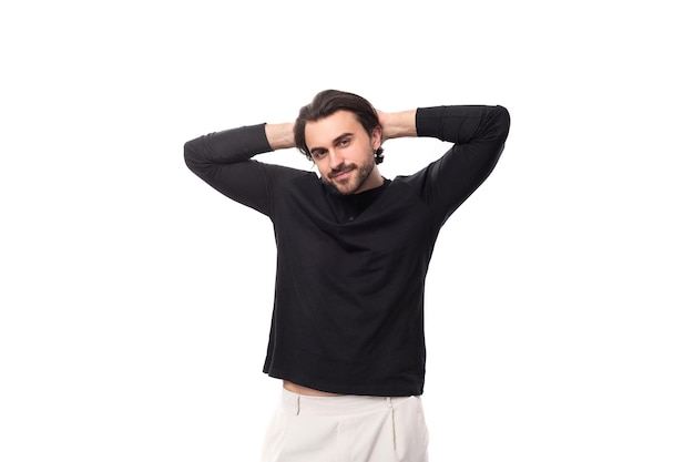 Young bearded brutal european macho man with ear piercing and with black hair on isolated white