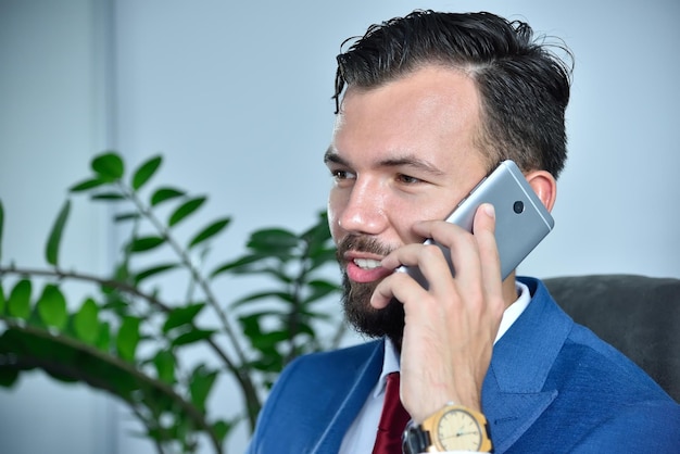 Young bearded businessman talking on mobile phone