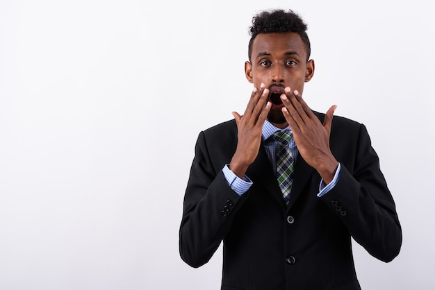 Young bearded businessman wearing suit against white