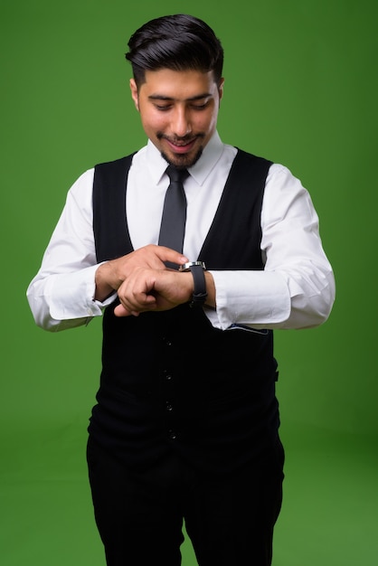 Young bearded Iranian businessman on green