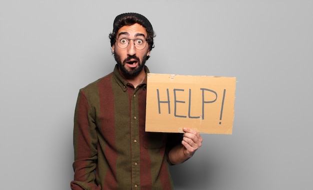 Young bearded man holding help placard