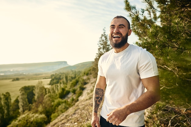 Young bearded man portrait outdoors in the mountains