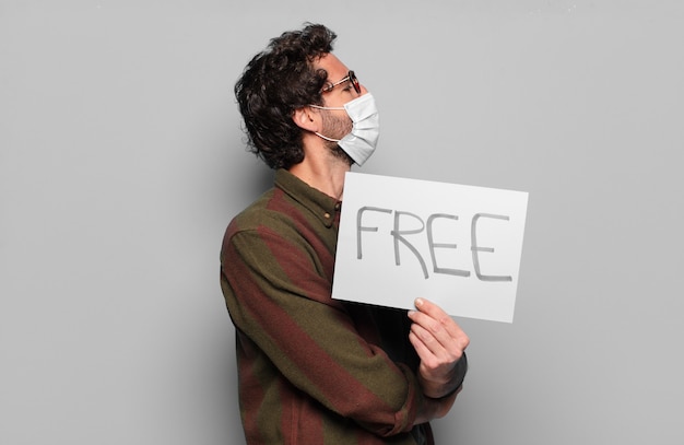 Photo young bearded man with a medical mask and free board