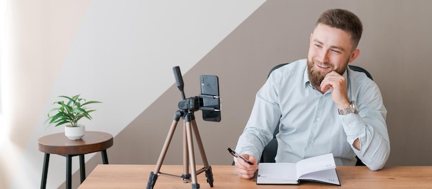 Young bearded man with smartphone and timetable notepad Closeup business