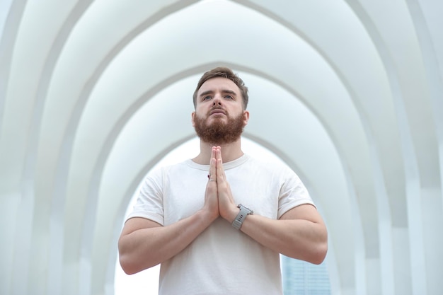 Young bearded religious man standing in temple white church pray meditate