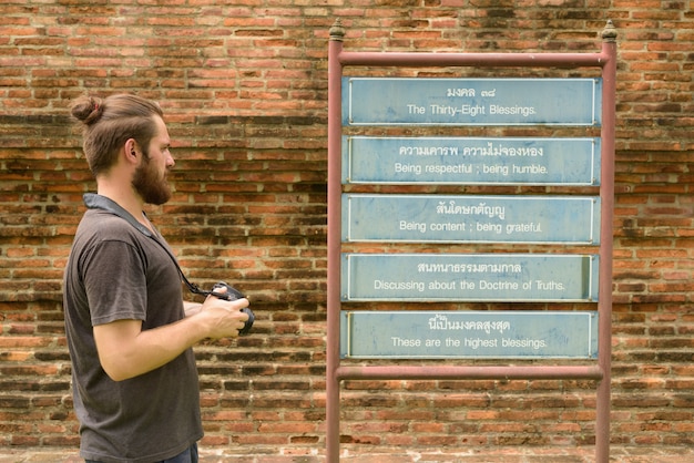 Young bearded tourist man having vacation in Ayutthaya, Thailand