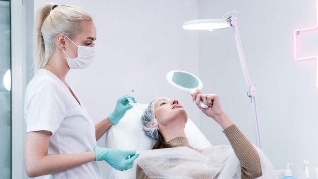 The young beautician doctor preparing to making injection in female lips