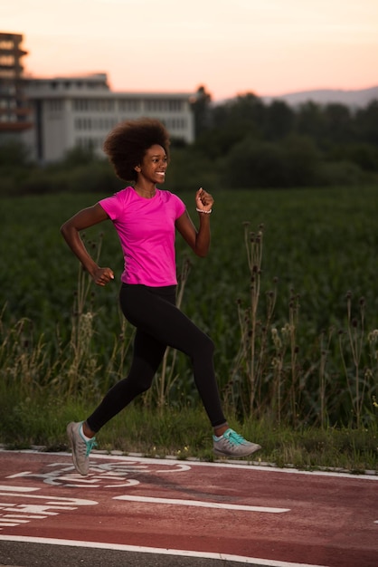 young beautiful African American woman enjoys running outside beautiful summer evening in the city