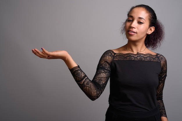 Young beautiful African woman on gray