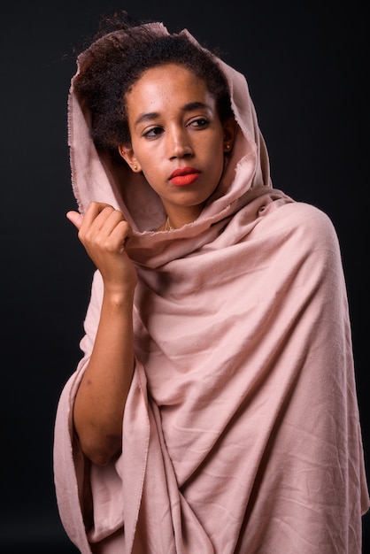 young beautiful African woman with Afro hair on black