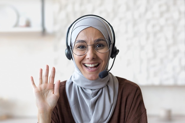 Young beautiful arab woman in hijab muslim working at home remotely business woman looking at camera