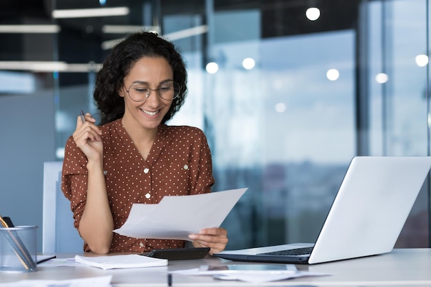 Young beautiful arabic business woman working in modern office with documents paperwork reading