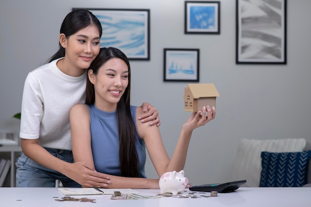 Young beautiful Asian lesbian couple saving money to buy a house LGBT women couple saving money for family and home