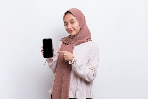 Young beautiful asian muslim woman demonstrating mobile cell phone isolated on white background