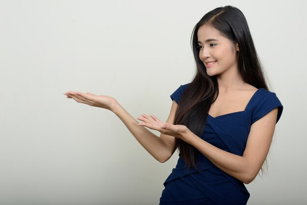  young beautiful Asian woman against white wall