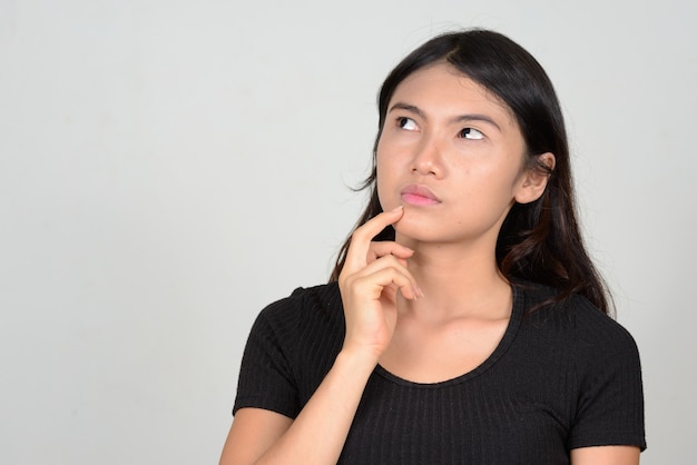  young beautiful Asian woman against white wall