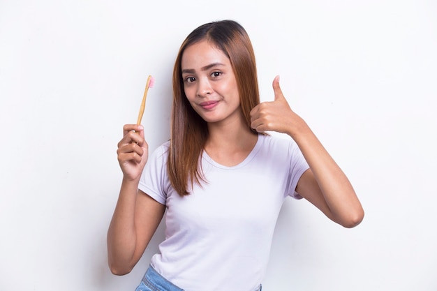 Young beautiful asian woman brushing her teeth isolated on white background