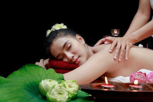 Young beautiful Asian woman having massage in spa environment.