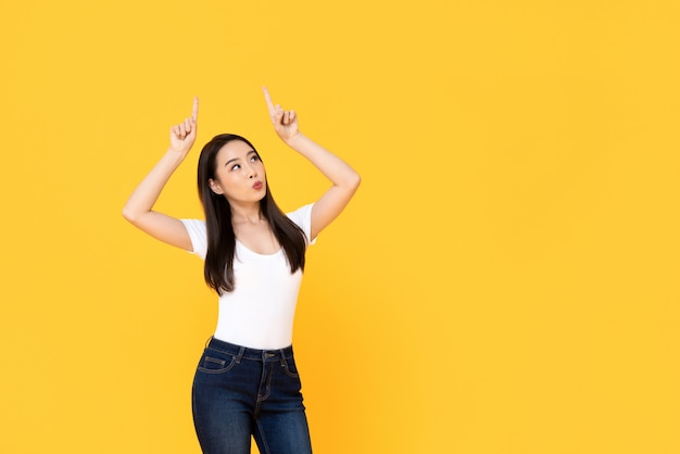 Young beautiful Asian woman pointing up with her two fingers