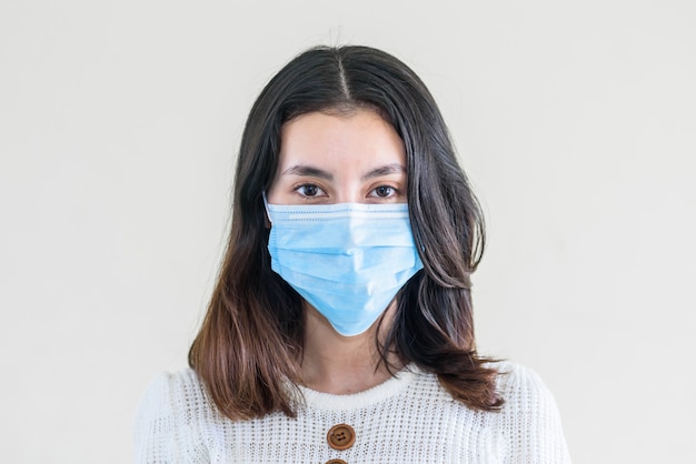 young  beautiful asian woman showing how to wear a medical mask