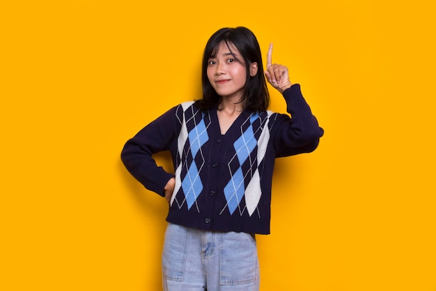 young beautiful asian woman thinking idea isolated on yellow background