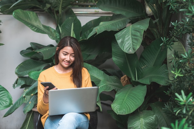 Young beautiful asian woman working with laptop at outdoor park