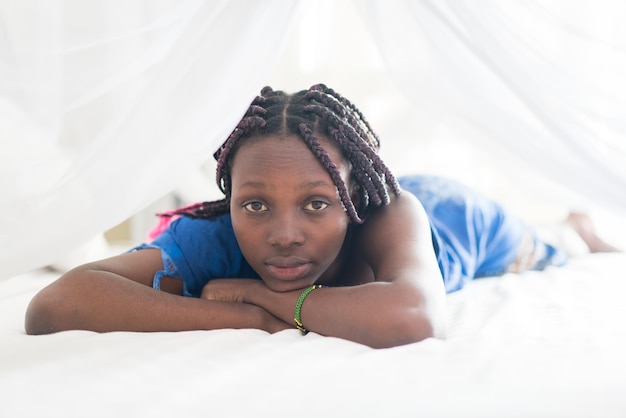 Young beautiful black girl awaking in bedroom bed